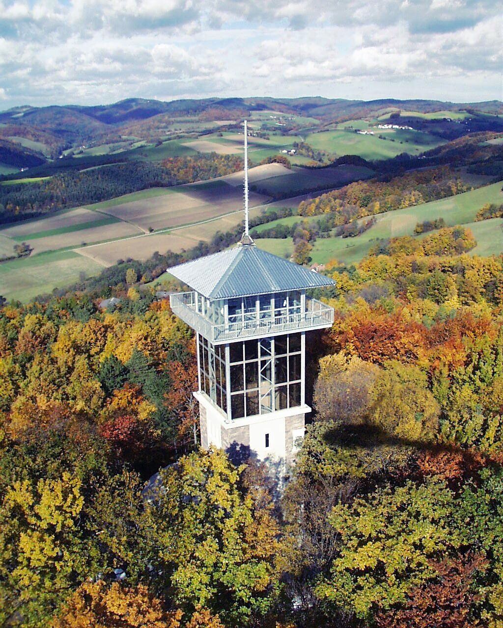 Der Museumsturm erhebt sich majestätisch über die herbstlich gefärbten Wälder, während die goldenen Blätter sanft im Wind tanzen. Ein atemberaubender Blick auf die umliegende Landschaft lädt dazu ein, die Ruhe und Schönheit der Natur zu genießen.