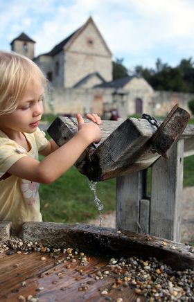 Ein Kind spielt mit Wasser auf dem Spielplatz in der Nähe des Kloster St. Anna. 