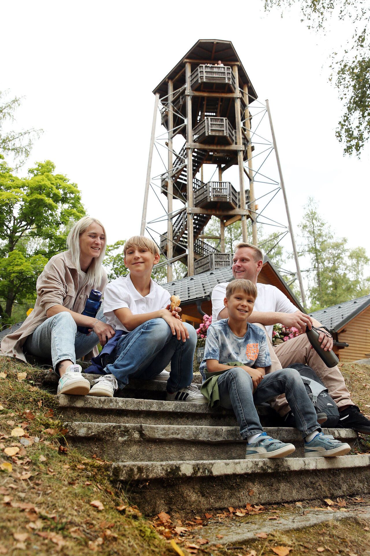 Eine Familie sitzt vor dem bekannten Aussichtsturm im Naturpark Blockheide. 