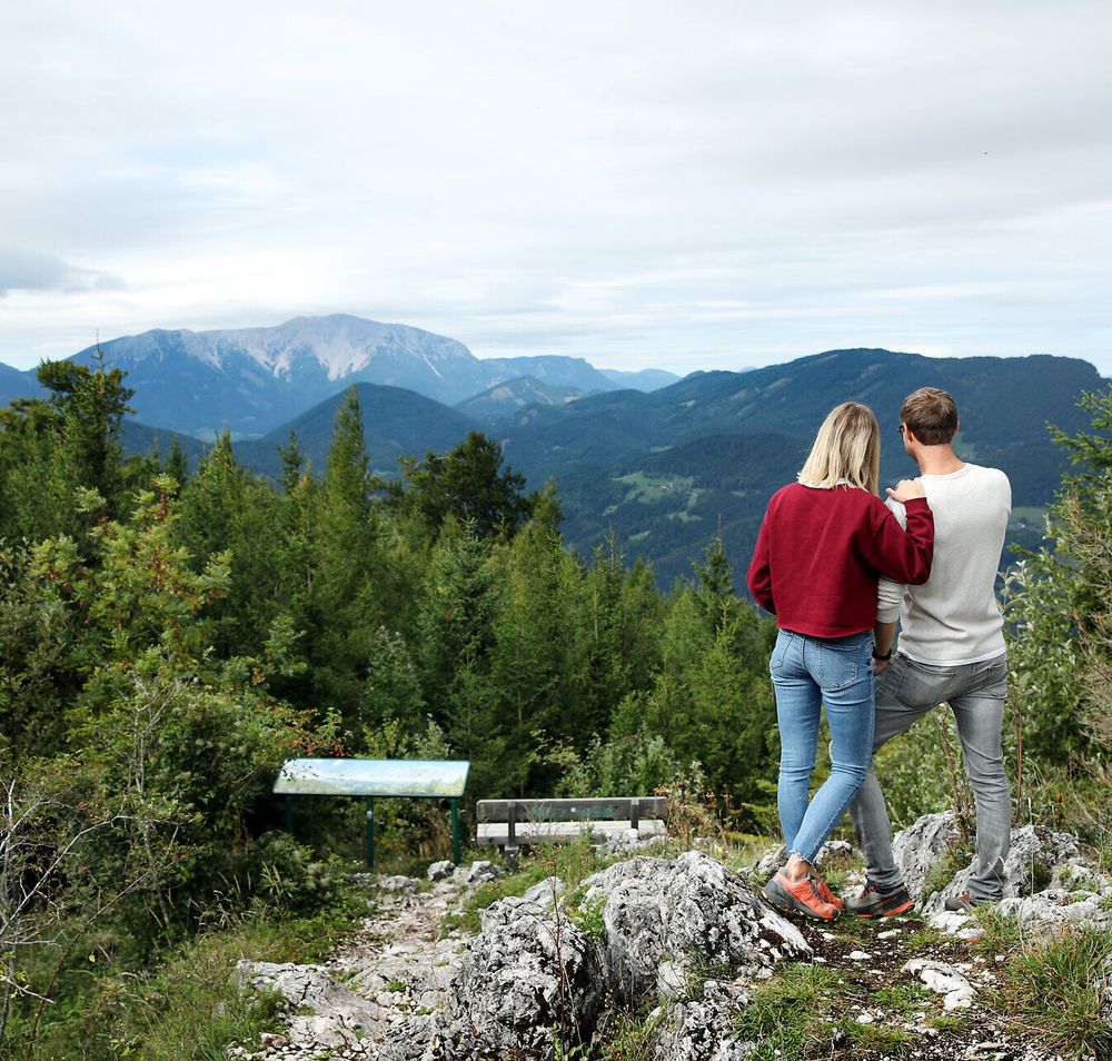Ein Paar genießt den Ausblick vom Naturpark Hohen Wand Richtung Schneeberg 